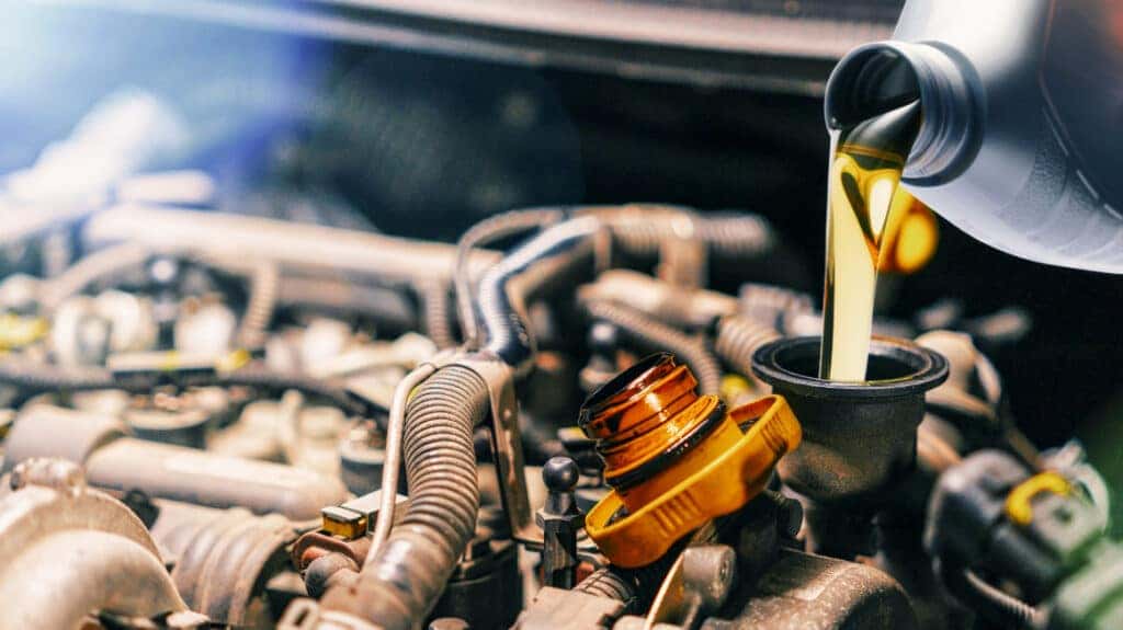 Clean engine oil being poured as part of a regular oil change