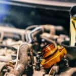 Clean engine oil being poured as part of a regular oil change