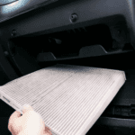 A technician replacing a car's cabin air filter