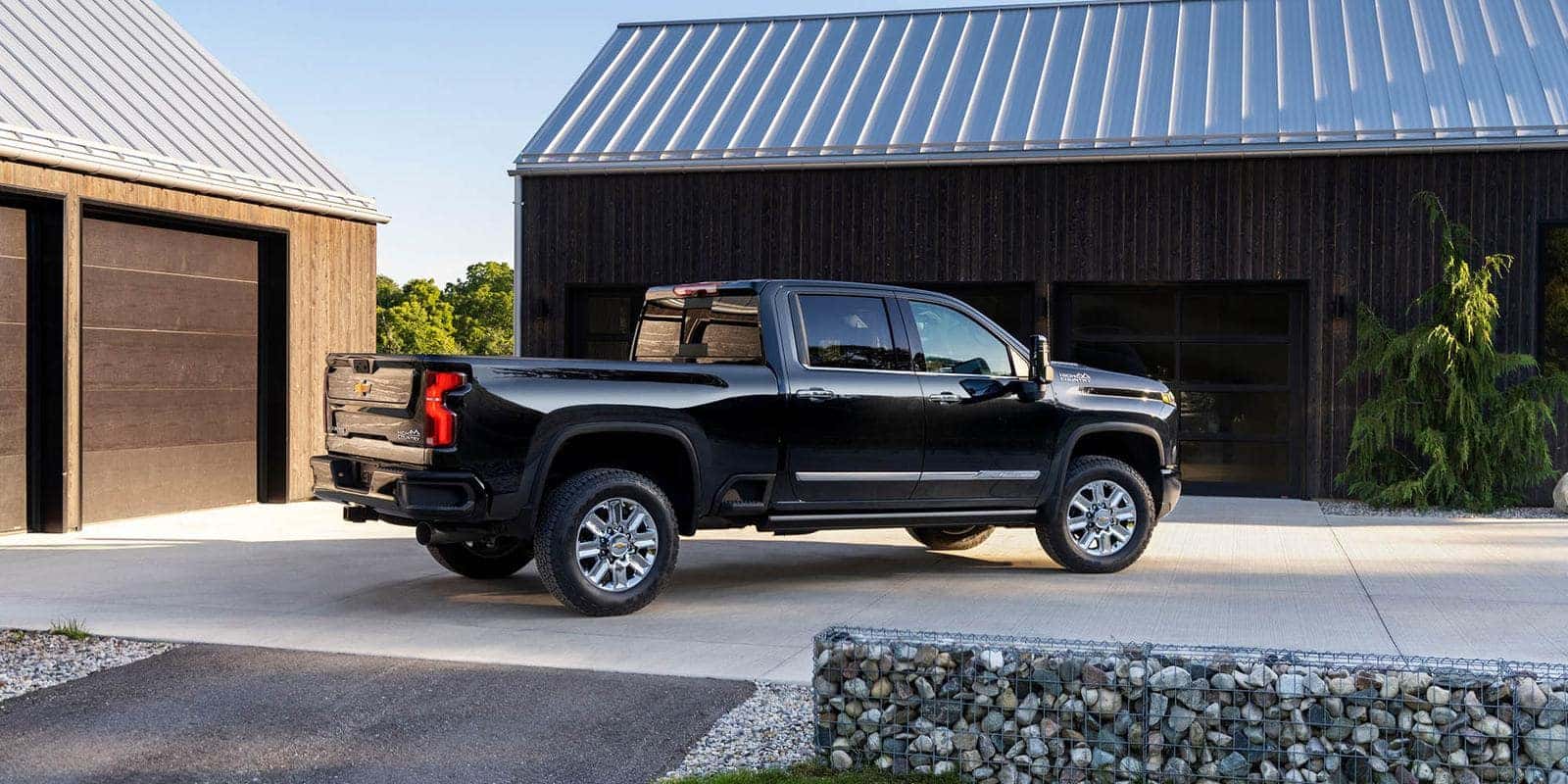 Black Chevrolet Silverado HD crew cab parked outside a farm shop
