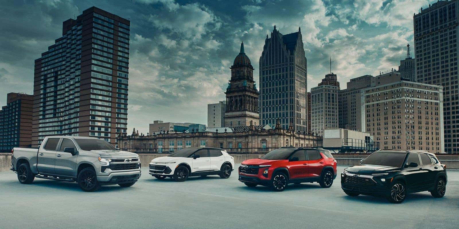 Chevrolet pickup and SUV lineup parked in front of a city skyline