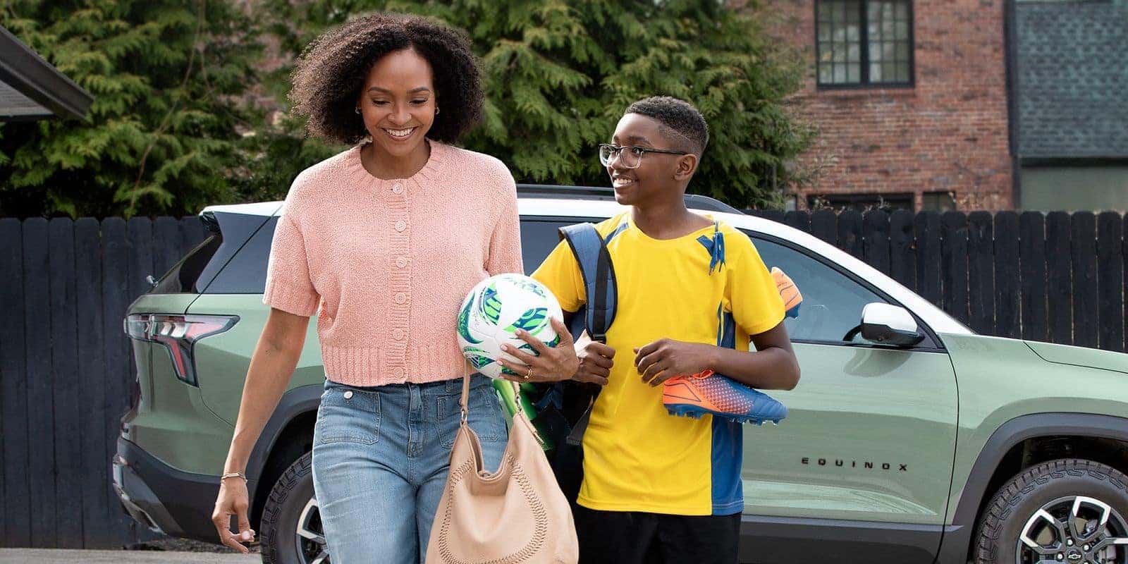 Madre e hijo caminando junto a una Chevrolet Equinox