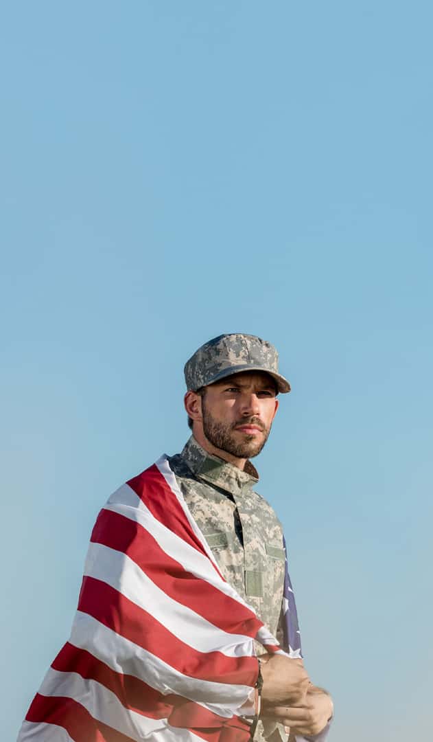 Veteran covering himself with an American Flag.