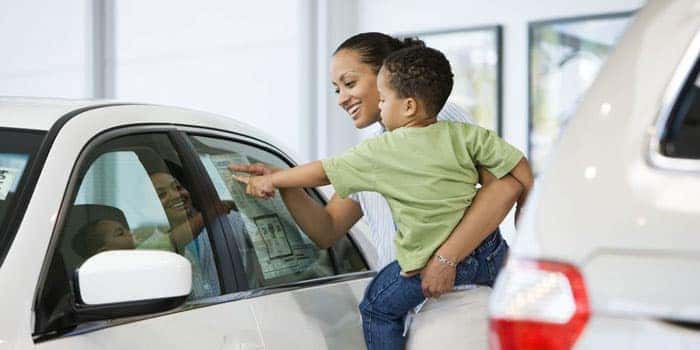 A mom and son looking at a vehicle in a showroom