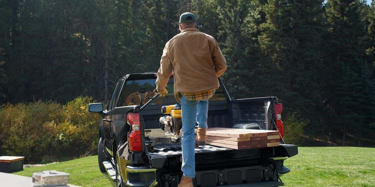 Man stepping into the bed of his Chevy Silverado 1500