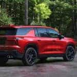 Red Chevy Traverse parked in a driveway in the woods