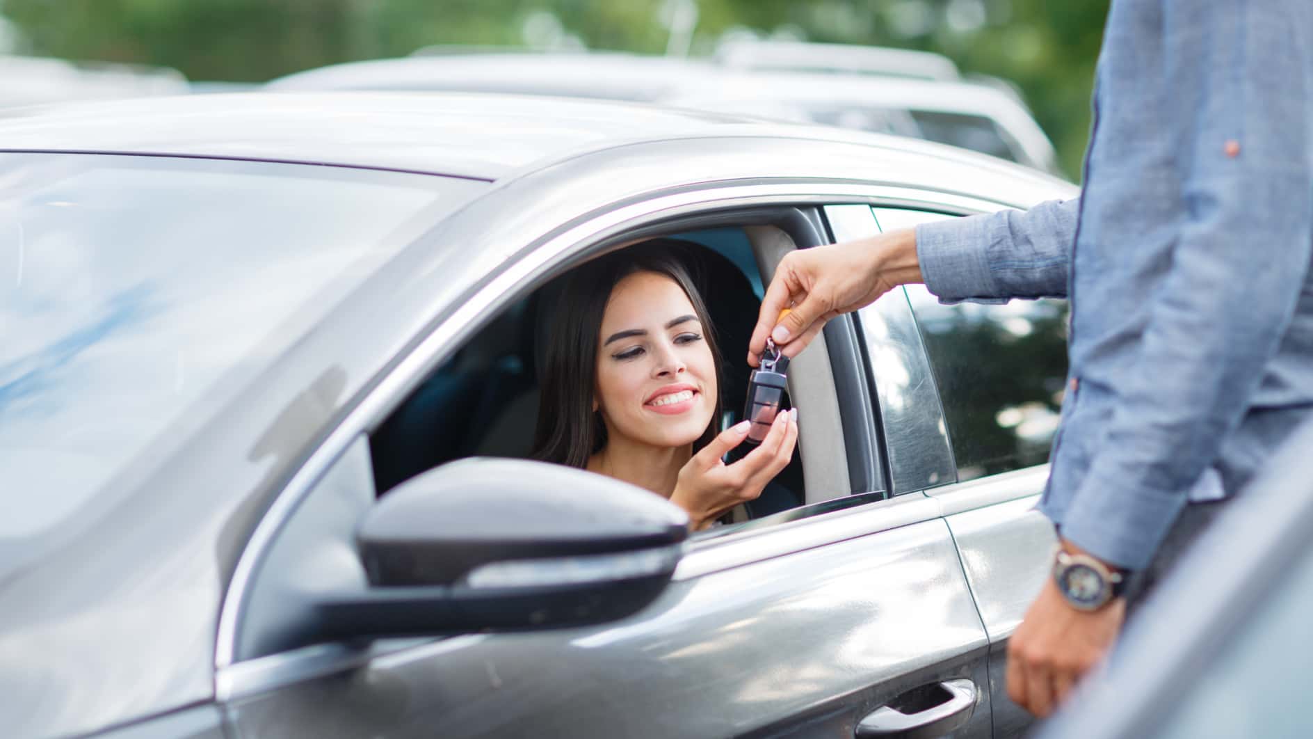 Young woman happily getting the keys to her new Chevy