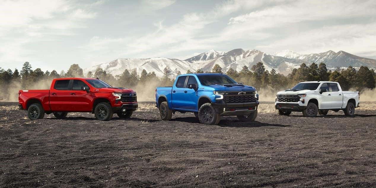 Three 2026 Chevy Silverado 1500s parked by a mountain