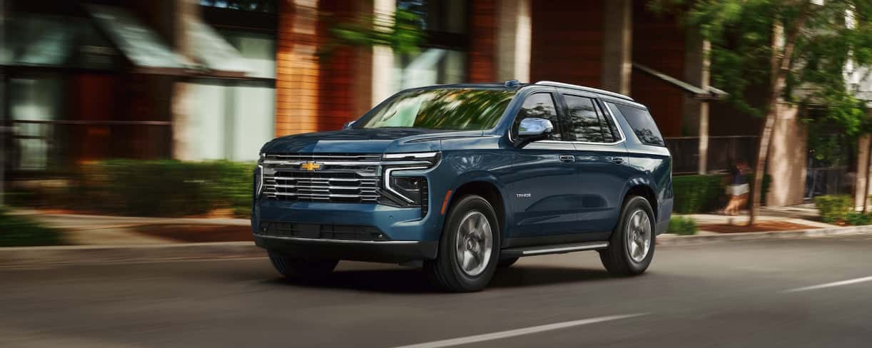 2026 Chevrolet Tahoe driving down a commercial road