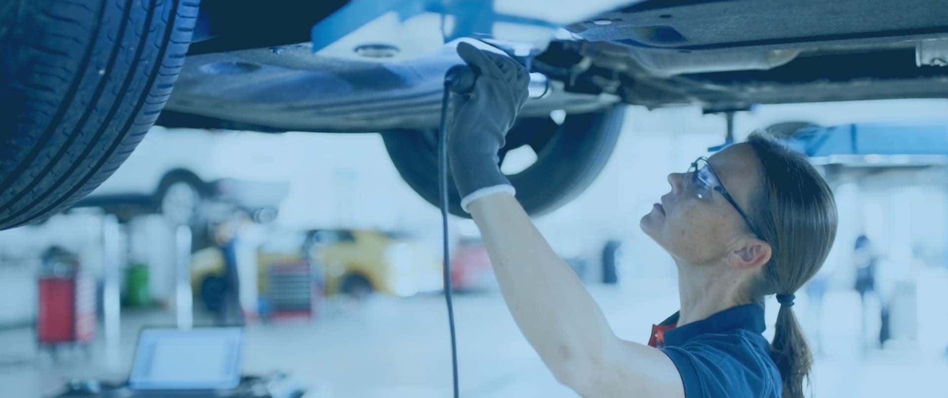 mechanic under car on car rack