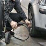 A Mechanic putting air in someone's tires