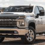2023 Chevy Silverado 2500 parked in field with mountain in background