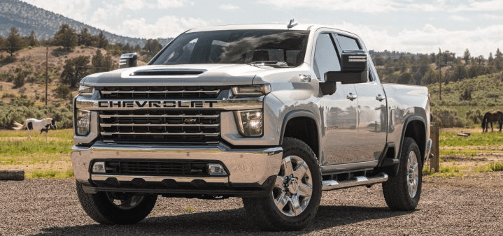 2023 Chevy Silverado 2500 parked in field with mountain in background