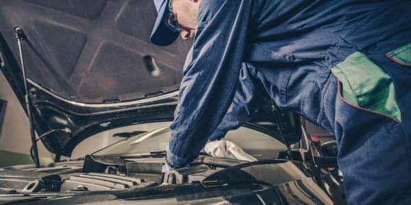 Service Technician working on vehicle under the hood