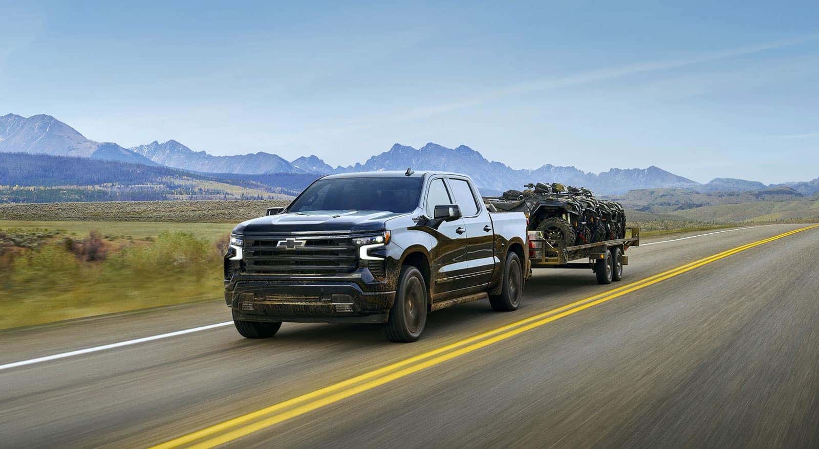 2027 Chevrolet Silverado 1500 towing a trailer on an open road