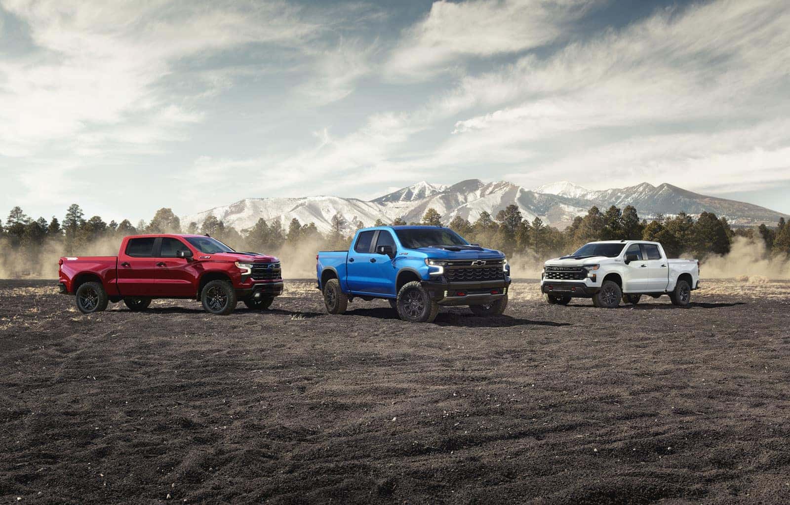 Three 2027 Chevrolet Silverado 1500 trucks parked side by side showing different trim levels