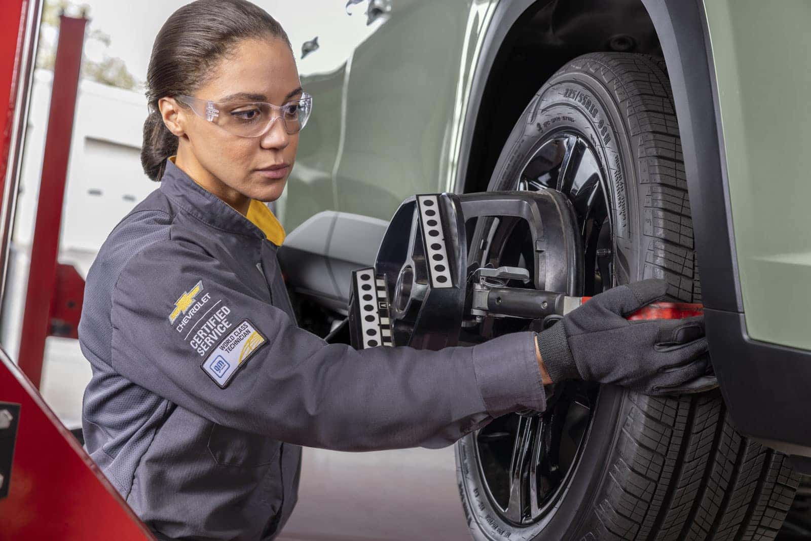 Emich Chevrolet service drive showing technician applying a Service Coupon Denver offer to a Chevy maintenance visit