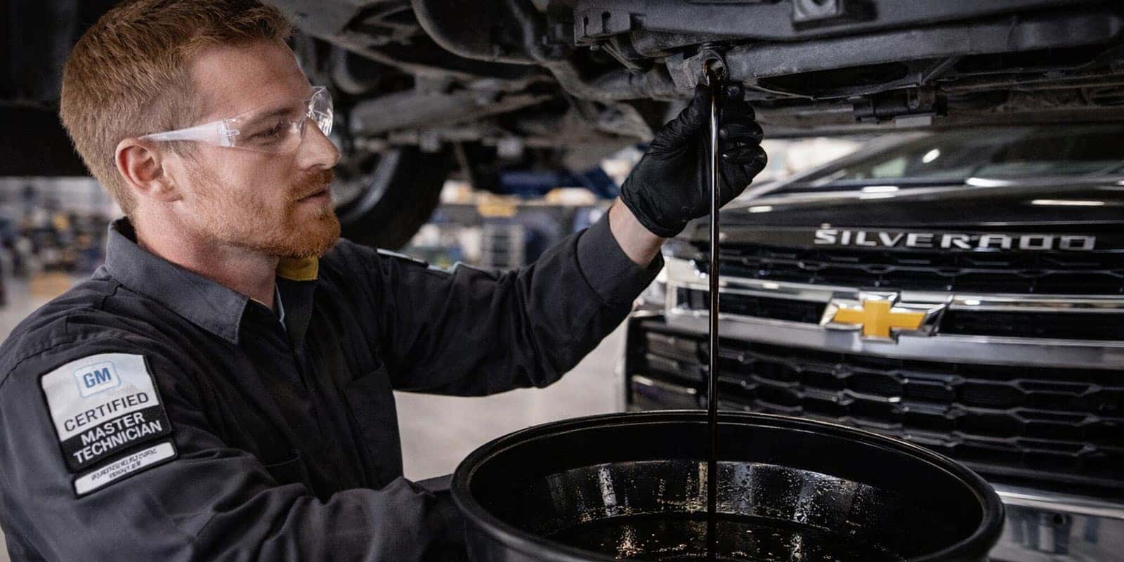 Chevrolet certified service technician performing maintenance on a commercial fleet vehicle at Emich Chevrolet Lakewood