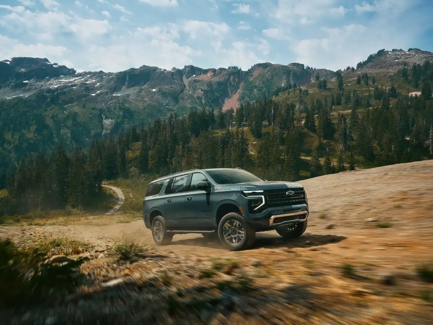 2026 Chevrolet Suburban exterior in mountain setting (official Chevrolet press image)