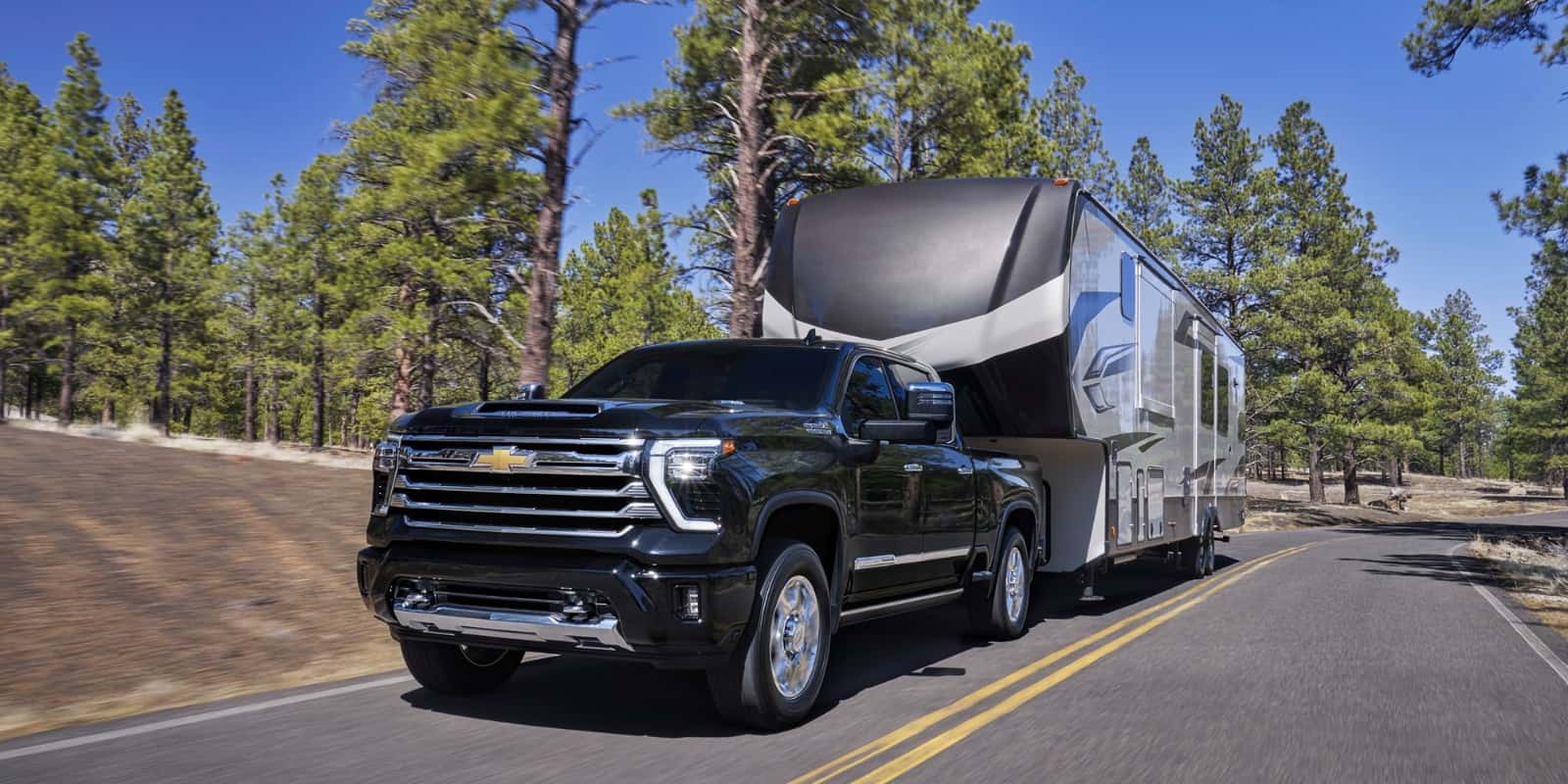 2026 Chevrolet Silverado HD with Duramax 6.6L Turbo-Diesel towing a heavy trailer — official Chevrolet image