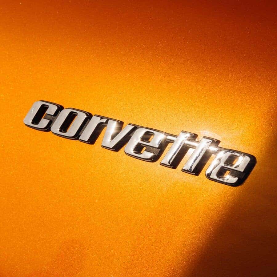 Chrome Corvette script badge on orange paint