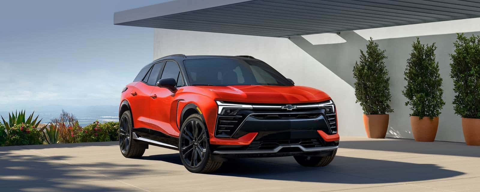 Red Chevy Blazer EV parked under a modern carport
