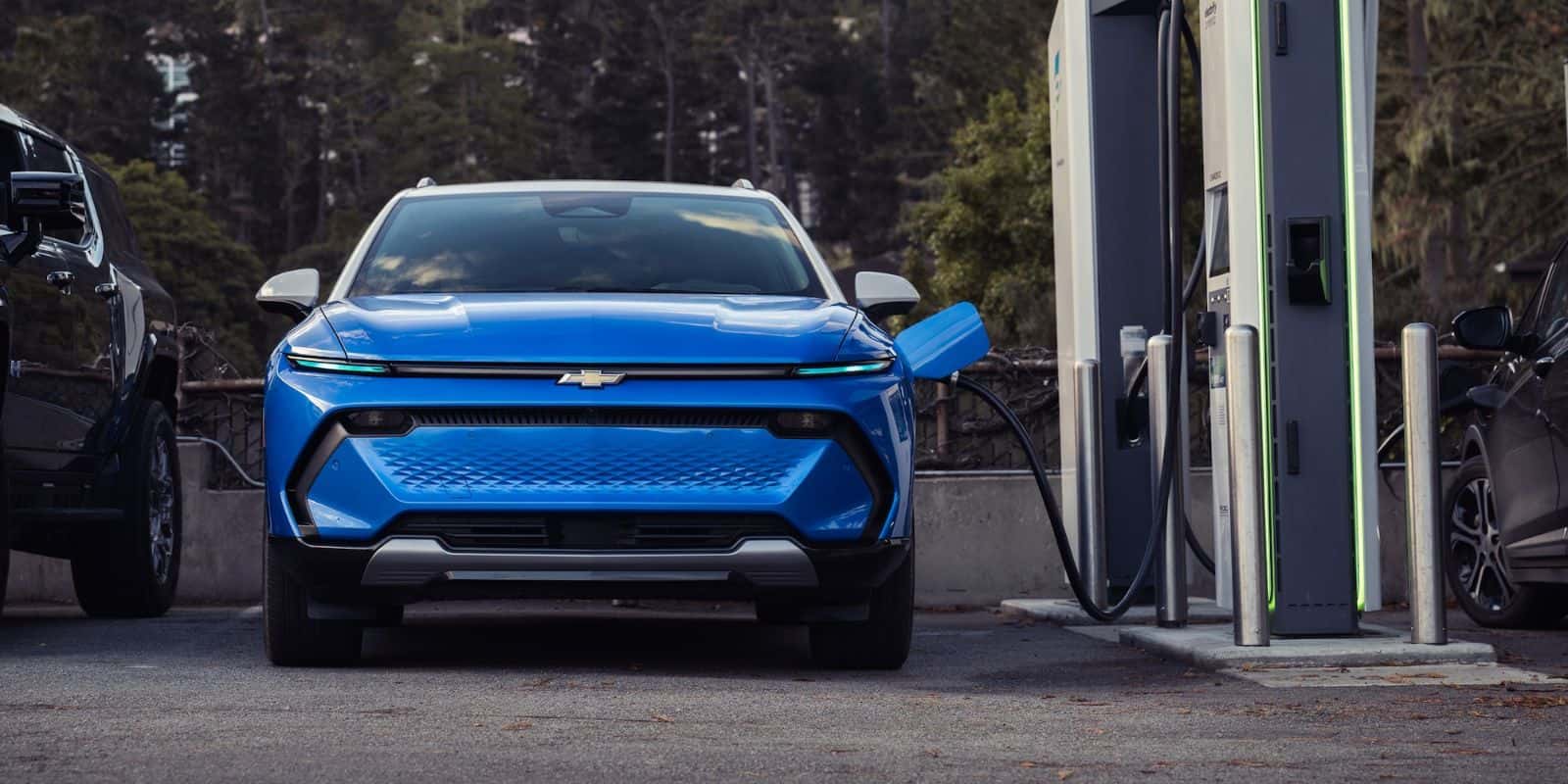 Blue Chevy Equinox EV plugged in at a public fast charger