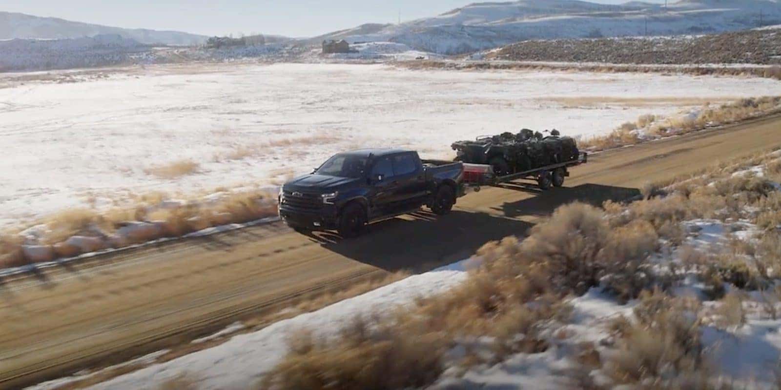 Chevy Silverado 1500 towing a trailer on a mountain road