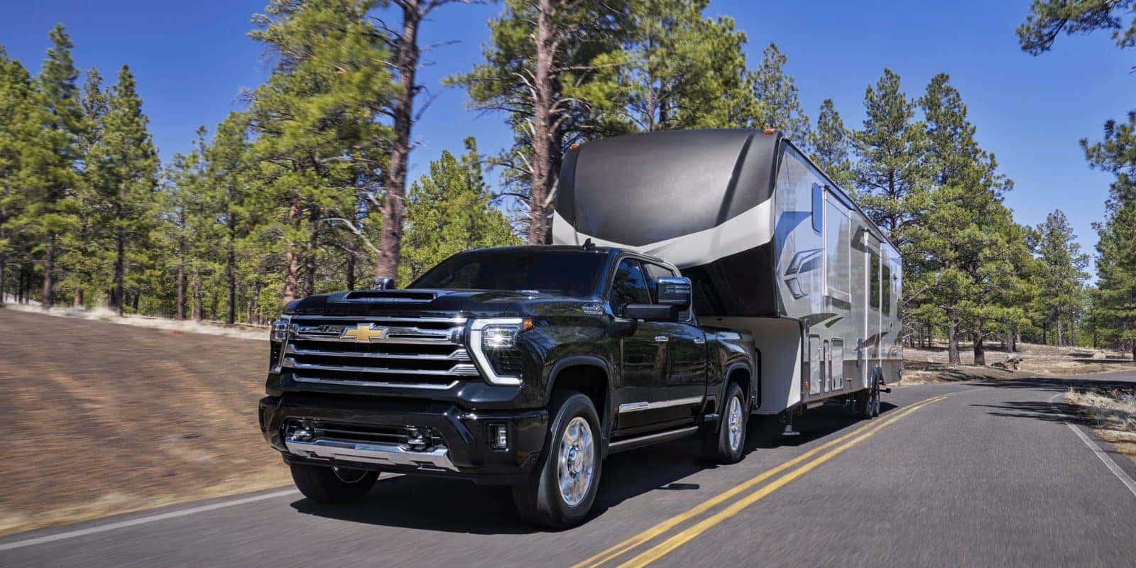 2026 Chevy Silverado 2500 HD towing a fifth-wheel camper, compared with the GMC Sierra 2500HD