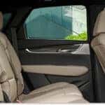 An interior view of the 2026 Cadillac XT5 showcasing the beige leather rear seats and matching door panel trim.