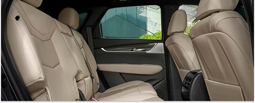 An interior view of the 2026 Cadillac XT5 showcasing the beige leather rear seats and matching door panel trim.