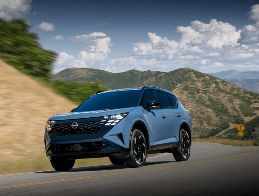 All-New 2027 Nissan Rogue Hybrid | Photo Courtesy: Nissan Blue Nissan Rogue Hybrid driving down highway