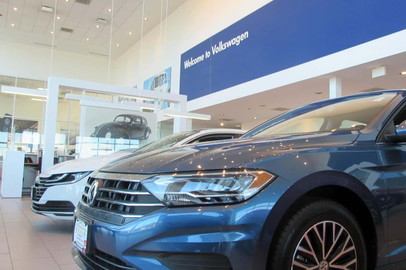 Two Volkswagen sedans in showroom at Kelly Volkswagen