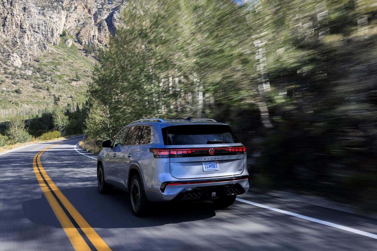 2027 Volkswagen Atlas in Silver Mist driving on a mountain road