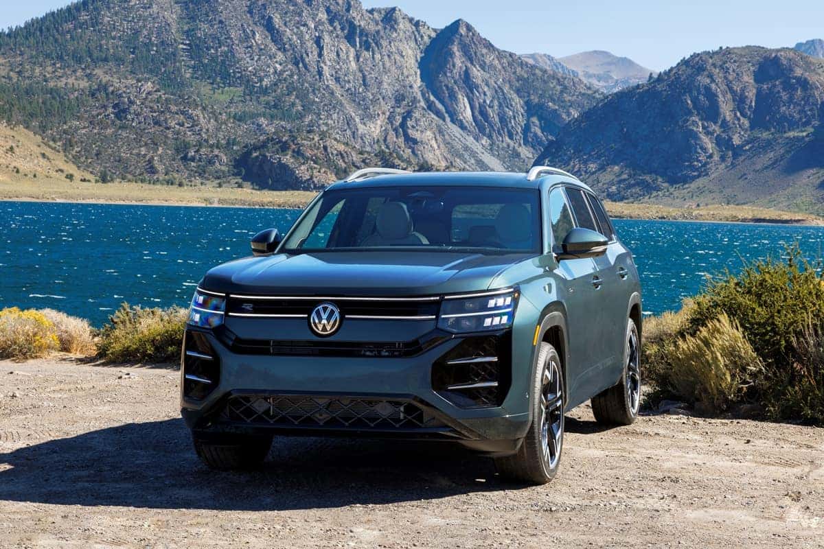 2027 Volkswagen Atlas in Sacramento Green Metallic beside a mountain lake