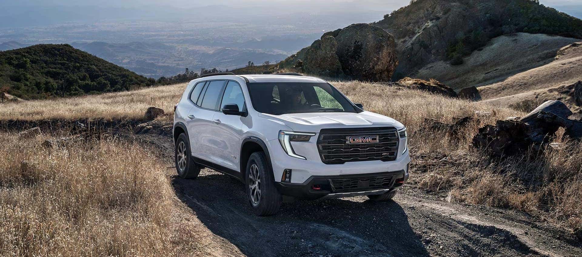 2027 GMC Acadia mid-size SUV driving on an off-road trail