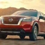 A red 2022 Nissan Pathfinder is shown from a low angle driving during a sunset after leaving a Lebanon TN Nissan dealer.