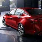 A man is walking next to a red 2021 Nissan Altima in a parking garage after leaving a Goodlettsville Nissan dealer.