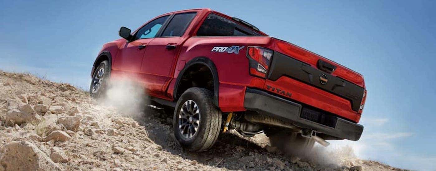 A red 2021 Nissan Titan Pro4x is driving through the desert.