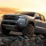 A grey 2022 Nissan Frontier Pro4x is show parked in the mountains at sunset after leaving a Nashville Nissan Frontier dealer.