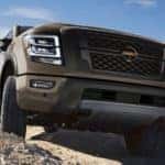A brown 2021 Nissan Titan PRO-4X is shown off-roading on a rocky path.