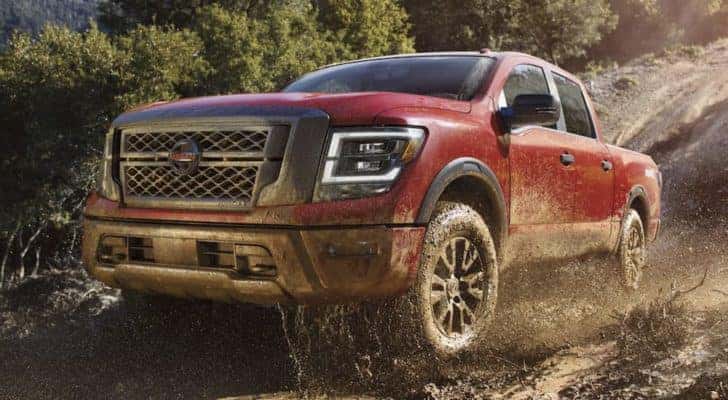 A red 2021 Nissan Titan is shown from the front off-roading in the mountains.
