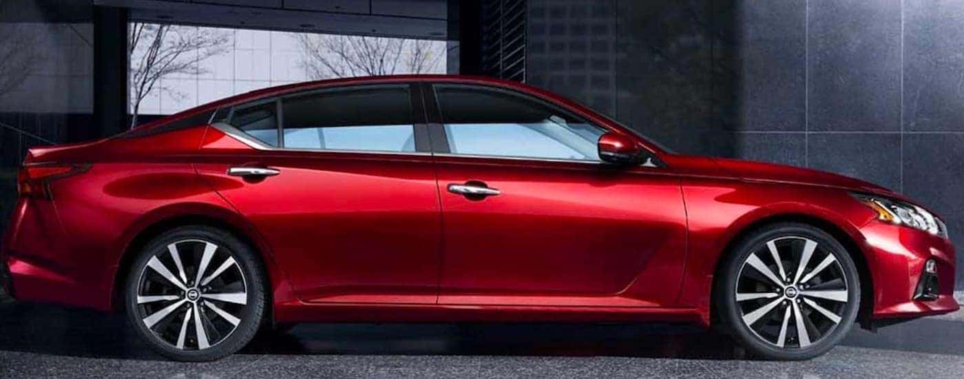 A red 2019 Nissan Altima is shown from the side parked in a modern gallery.