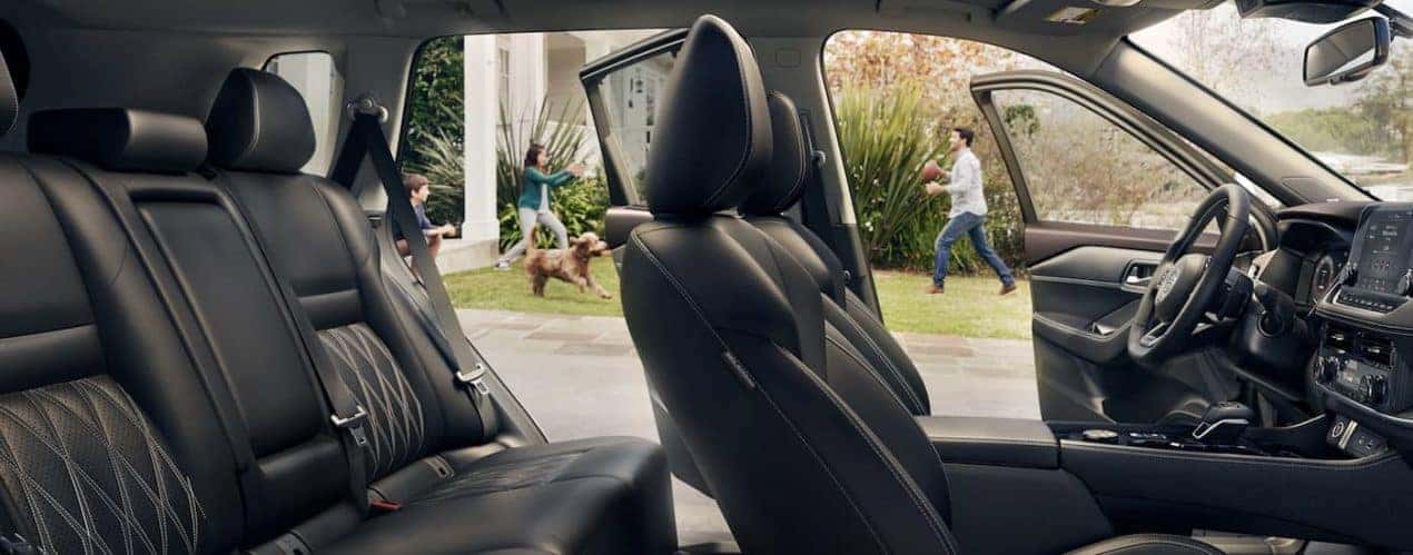 The black interior of a 2022 Nissan Rogue shows two rows of seating.