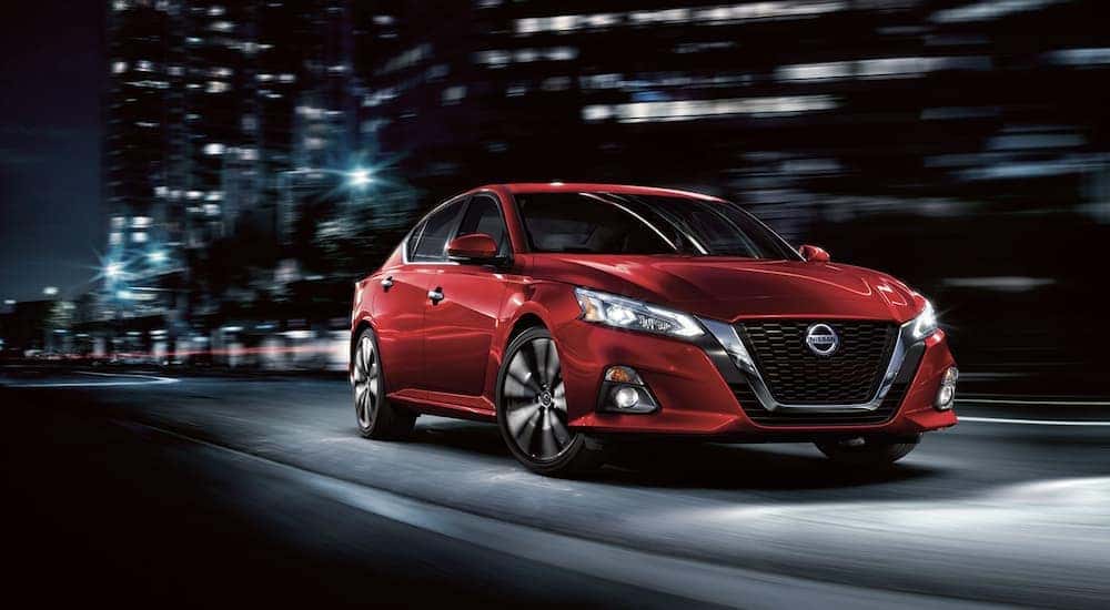 A red 2022 Nissan Altima is shown driving at night after leaving a Goodlettsville Nissan dealer.