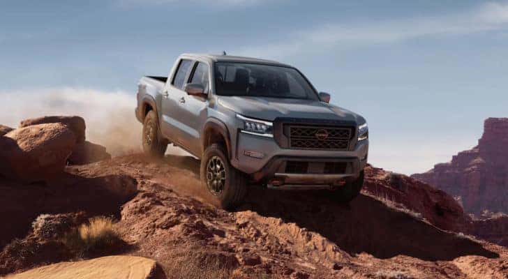 A grey 2022 Nissan Frontier is shown from the front off-roading after leaving a lifted truck dealer.