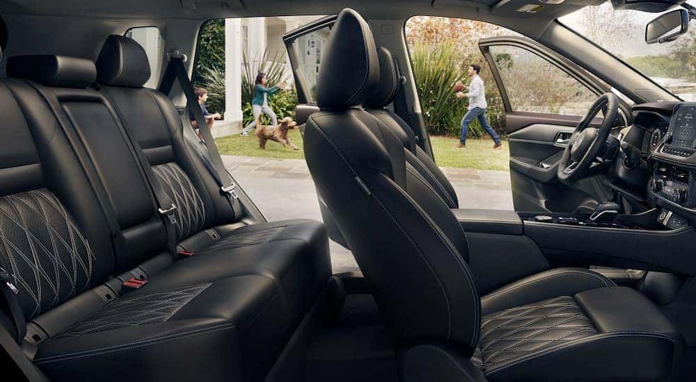 The black interior of a 2022 Nissan Rogue shows two rows of seating.