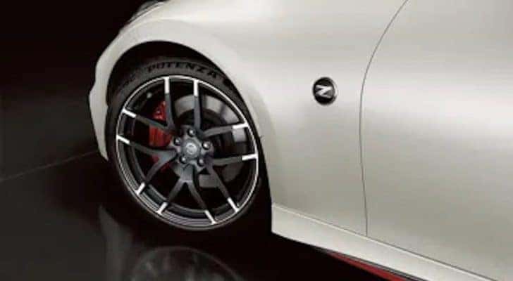 A closeup shows the wheel of a white 2020 Nissan 370z Nismo.