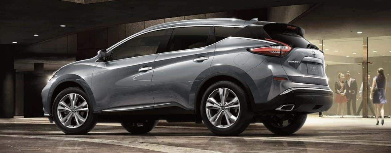 A silver 2023 Nissan Murano is shown from the side parked in a gallery.