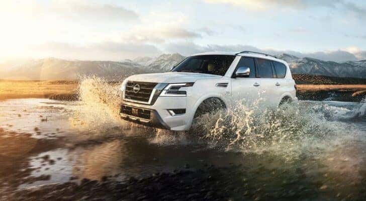 A white 2023 Nissan Armada is shown off-roading through a river.